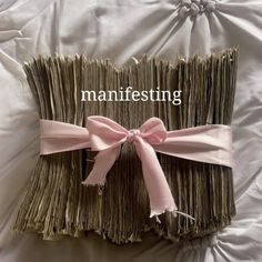 there is a folded book with pink ribbon on it and the words manfesting