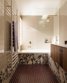 a bathroom with marble counter tops and tile flooring, along with a bathtub