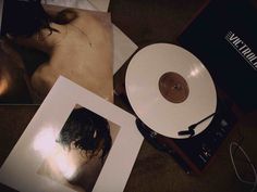 a record player sitting on top of a table next to two pictures and an album