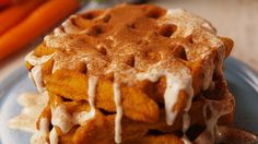 a stack of waffles sitting on top of a plate next to carrots