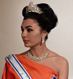 a woman in an orange dress wearing a tiara