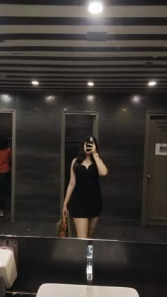 a woman taking a selfie in the bathroom mirror