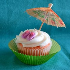 a cupcake with an umbrella and the number 50 on top is sitting on a green wrapper