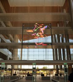 the inside of a large building with lots of windows and artwork on the wall above it