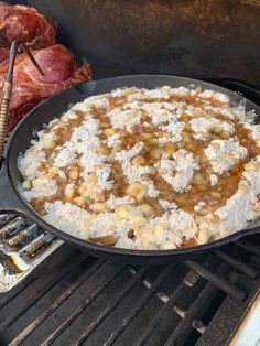 a pan filled with food sitting on top of an open grill