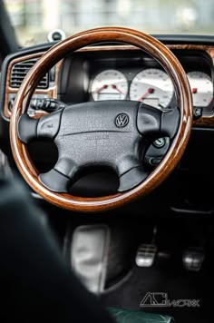 the steering wheel and dashboard of a car with wood grained dash tape on it