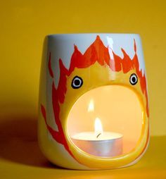 a yellow candle holder with a burning candle in the shape of a face and eyes