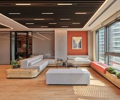 a living room filled with lots of furniture and large windows next to a wooden floor