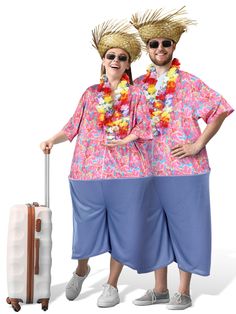 two people with hats and leis standing next to a suitcase