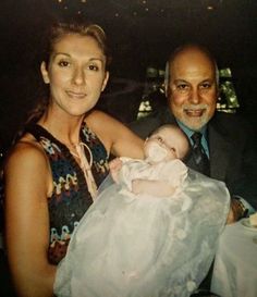 a man and woman holding a baby at a dinner table