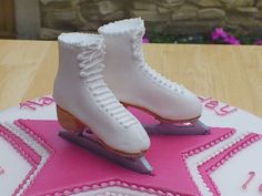 a birthday cake decorated with ice skates on top of a pink star shaped plate