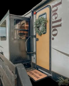 an open door to a trailer that has a wreath on the front and side of it