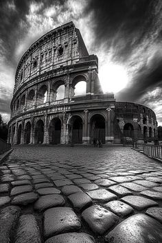 black and white photograph of the colossion in rome, italy with dramatic clouds