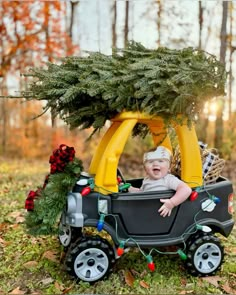 a baby in a toy car with a christmas tree on top