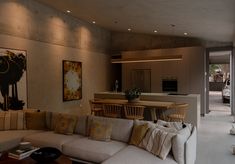 a living room filled with furniture next to a kitchen