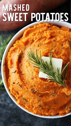 a bowl filled with mashed sweet potatoes and topped with a sprig of parsley