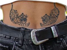 the back of a woman's stomach with tattoos on her body and two tigers