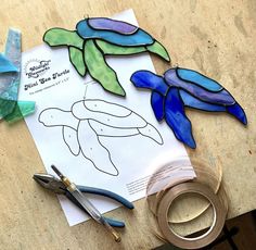 some crafting supplies are laying out on a table with paper and scissors next to it