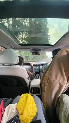 two people sitting in the back seat of a car