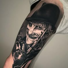 a man's arm with an evil clown tattoo on it