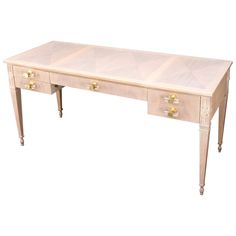 a white desk with two drawers and gold knobs