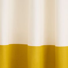 a yellow and white curtain hanging from a window