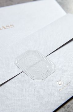 two white envelopes with the word miss written on one side and an embossed logo on the other