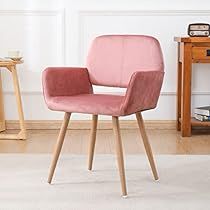 a pink chair sitting next to a wooden table