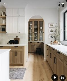 a kitchen with wooden cabinets and white counter tops next to a large open doorway that leads into the dining room