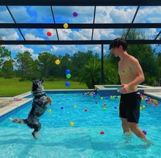 a man and his dog are playing in the pool