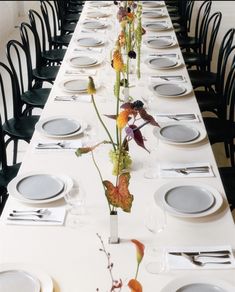 a long table is set with plates and silverware