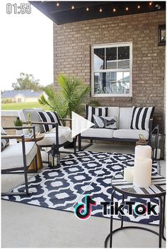 a black and white rug sitting on top of a patio next to a table with candles