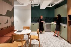 two women are standing in the kitchen talking