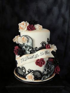 a three tiered wedding cake decorated with skulls and roses is shown on a black background