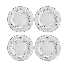 four white plates with red and green flowers on the rims, one is empty