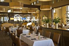 a dining room with tables and chairs covered in white tablecloths