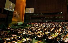 a large room filled with lots of people sitting at desks in front of a projector screen