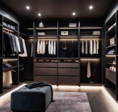 a walk - in closet with black and white walls, lights on the ceiling and drawers