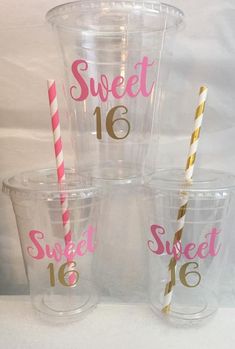 four clear cups with pink and gold straws