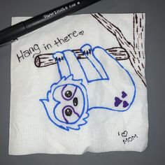 a napkin with a drawing of a slotty hanging in there on it next to a black marker