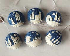 four blue and white ornaments hanging from strings