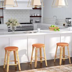 three stools are in front of the kitchen island