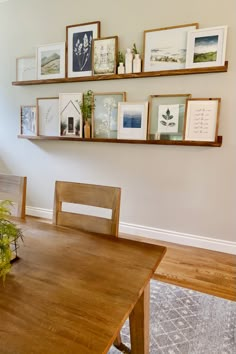 a dining room table with some pictures on the wall