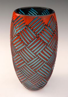 an orange and blue vase with lines on it