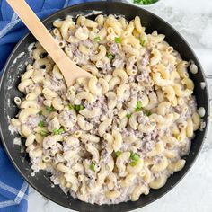 a skillet filled with macaroni and cheese on top of a blue towel