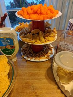 three tiered trays filled with food on top of a wooden table