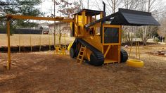 a yellow and black swing set in the middle of a field