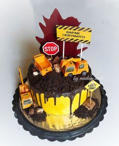 a cake that is decorated with construction vehicles and road signs on top of the cake