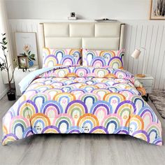 a bed with a rainbow comforter and pillows