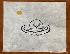 a piece of paper with a drawing of a cat in the water